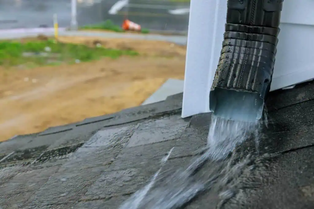 Drainage pipe releasing water from roof to prevent leaks and water damage.