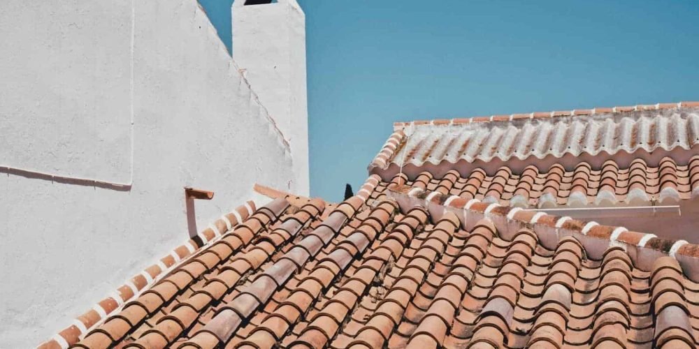 Close-up of terracotta roof tiles and chimney on a residential home.
